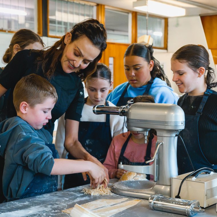 Yvonne showing children how to make fresh pasta in a class