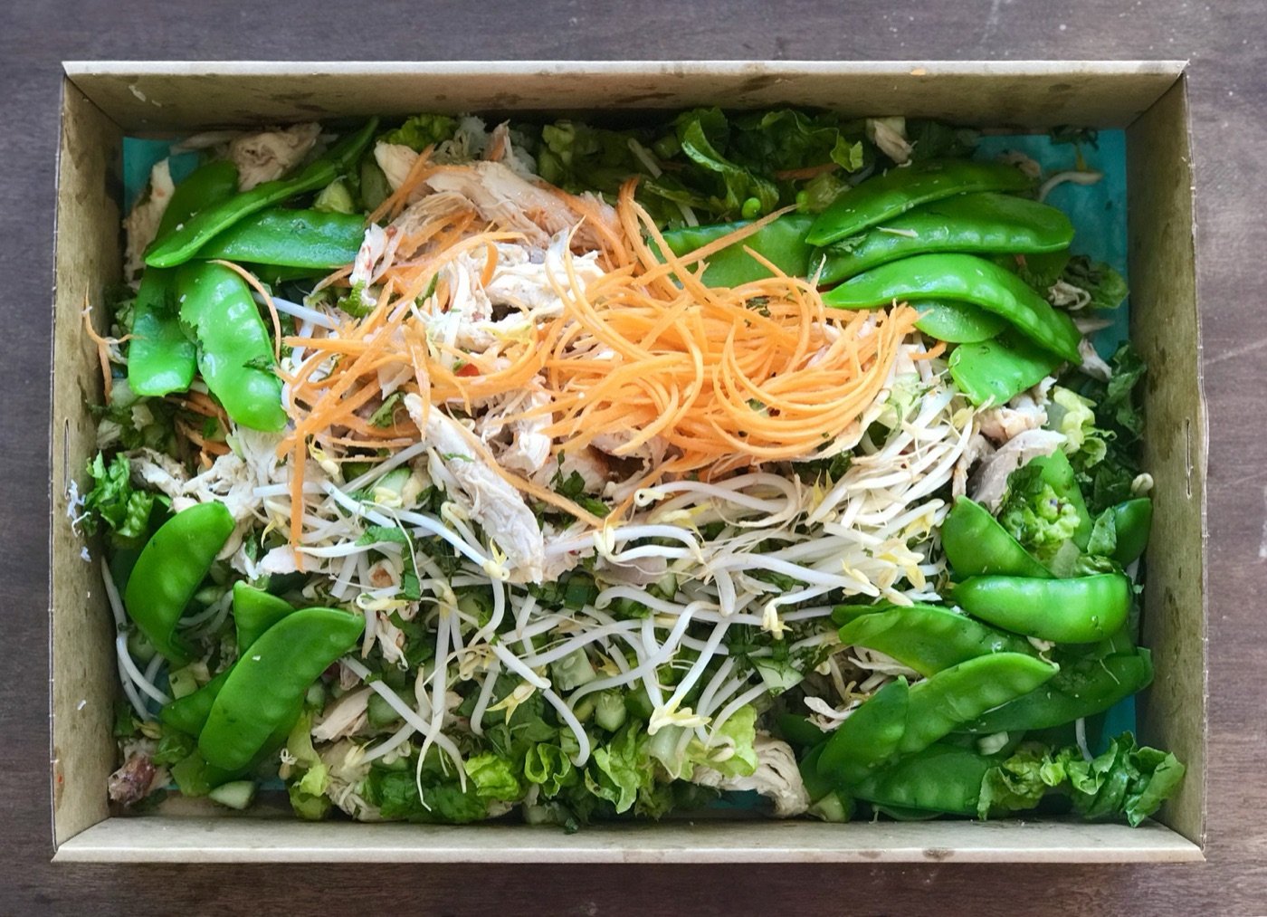 A boxed Asian chicken salad with snow peas and bean sprouts