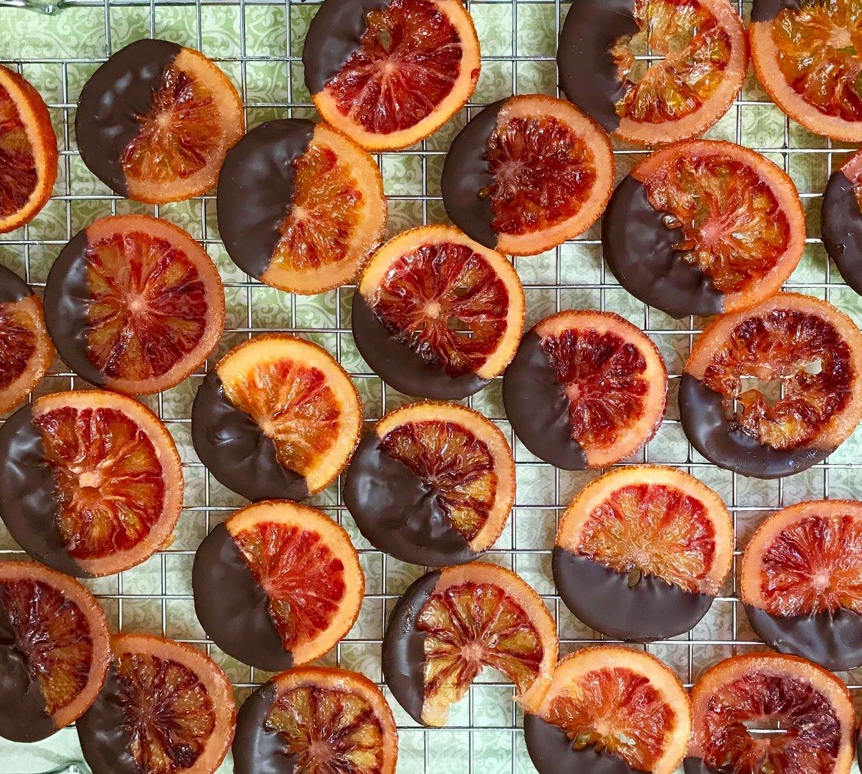 Blood orange slices half-dipped in dark chocolate