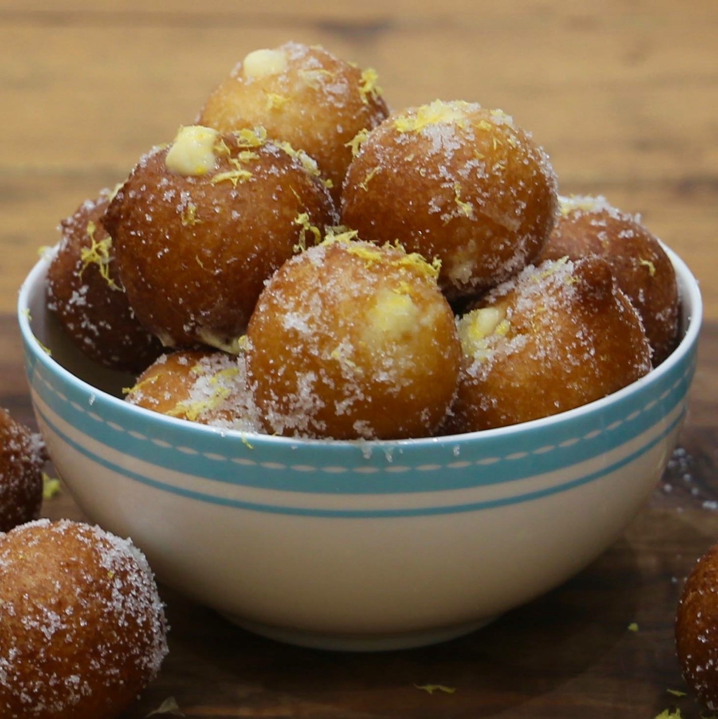 Lemon-sugar doughnut holes in a blue-striped bowl