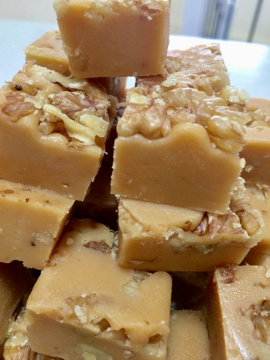 Squares of caramel walnut fudge, stacked on a plate