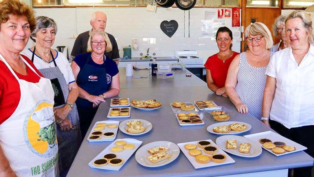 A class gathered proudly around their sweet and savoury tarts