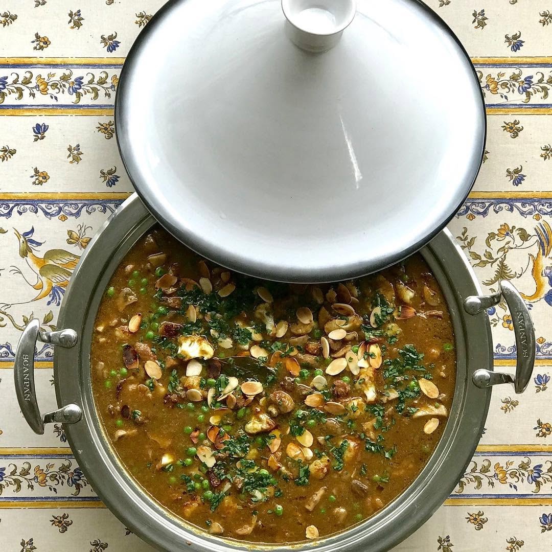 A slow-cooked tagine scattered with toasted almonds and peas