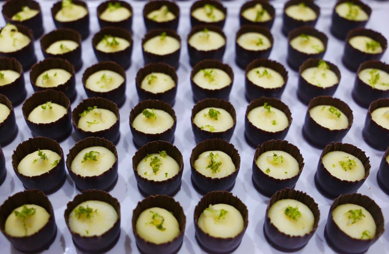 Rows of dark chocolate cups filled with lime curd