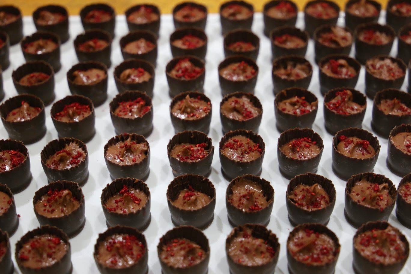 Little chocolate cups piped with mousse and flecked with raspberry