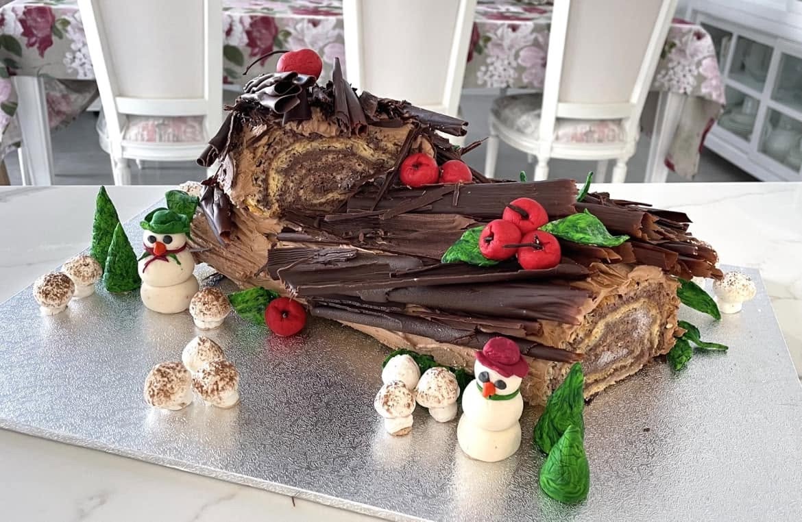 A chocolate yule log trimmed with marzipan snowmen and meringue mushrooms