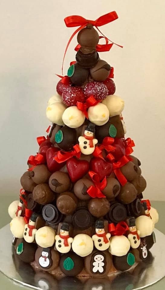 A chocolate truffle tower shaped like a Christmas tree and tied with red bows