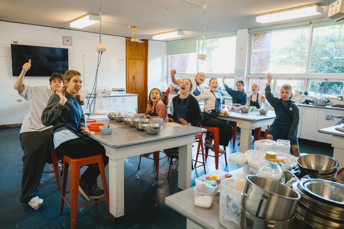 The whole class cheering with hands in the air at the end of a session