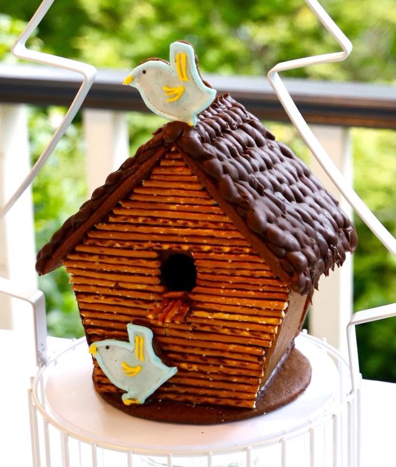 A pretzel-walled gingerbread birdhouse with little icing birds