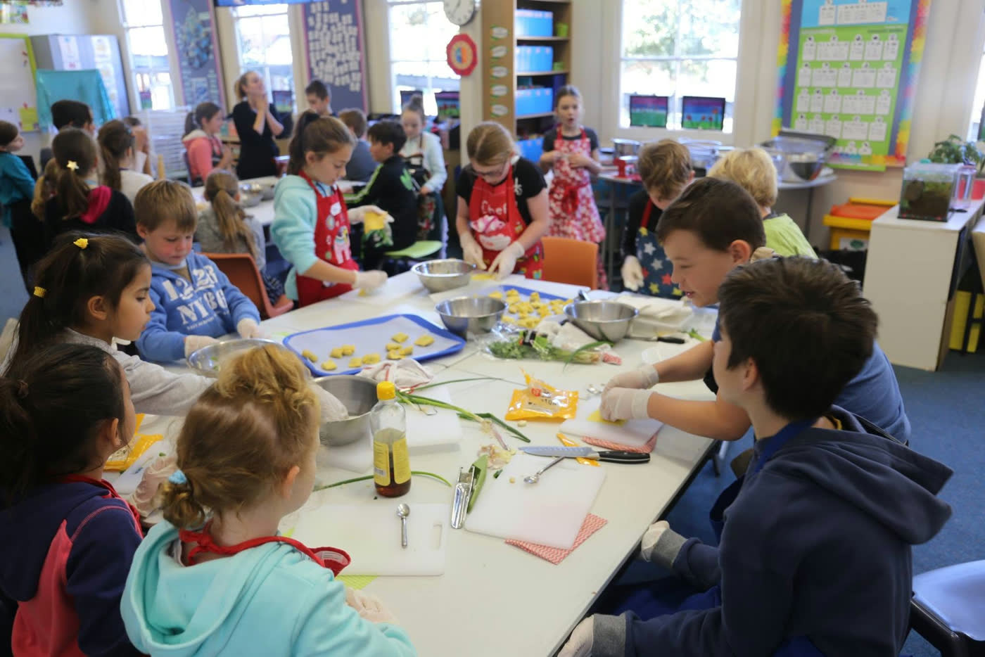 A busy classroom session with children working at tables across the room